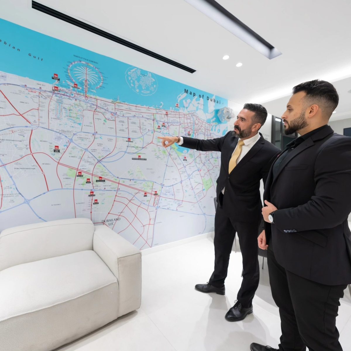 Mo Daas walking through a Dubai area map at the fäm Properties office